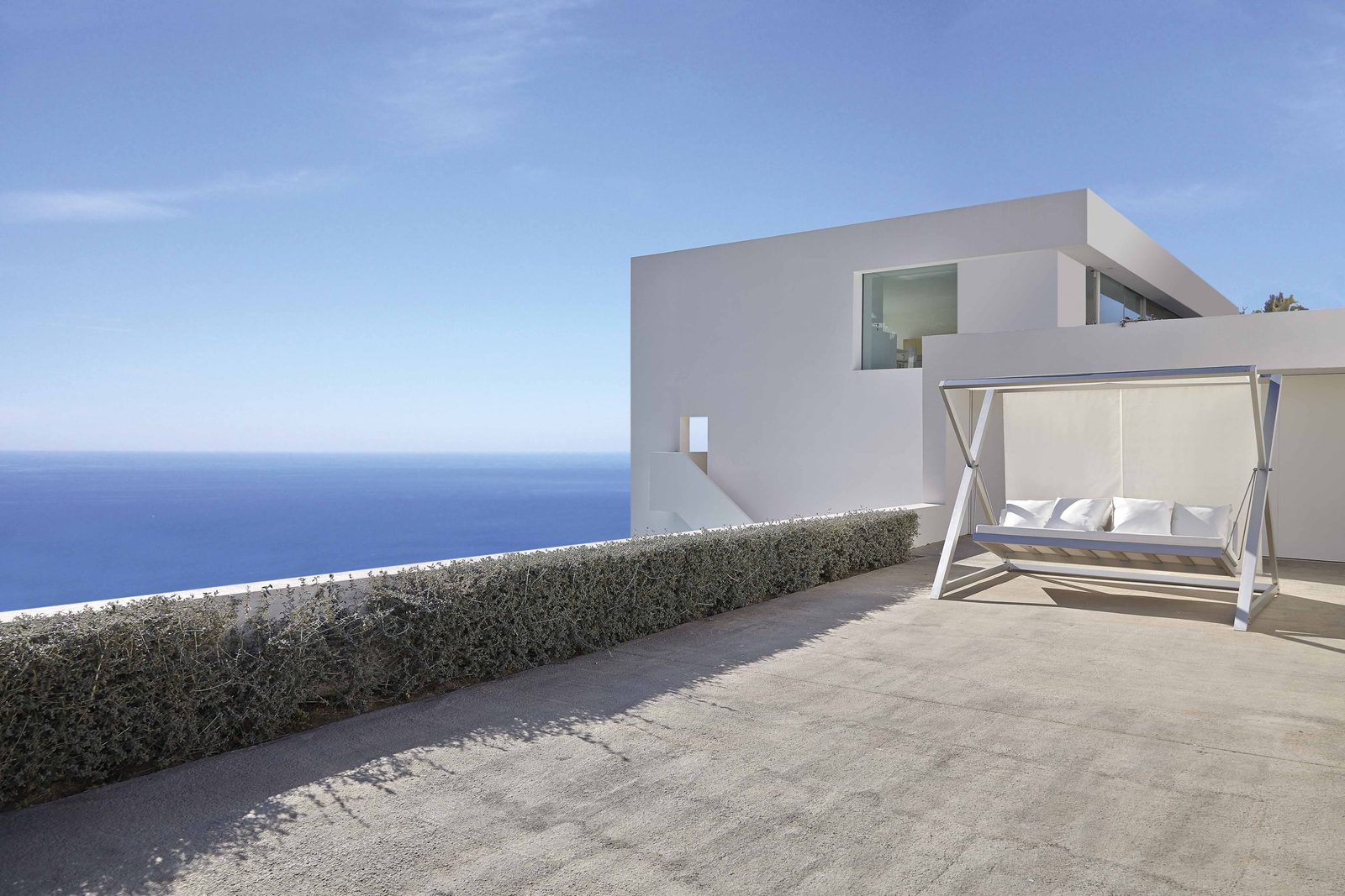 Nao Nao garden swing in white on a terrace above the sea.