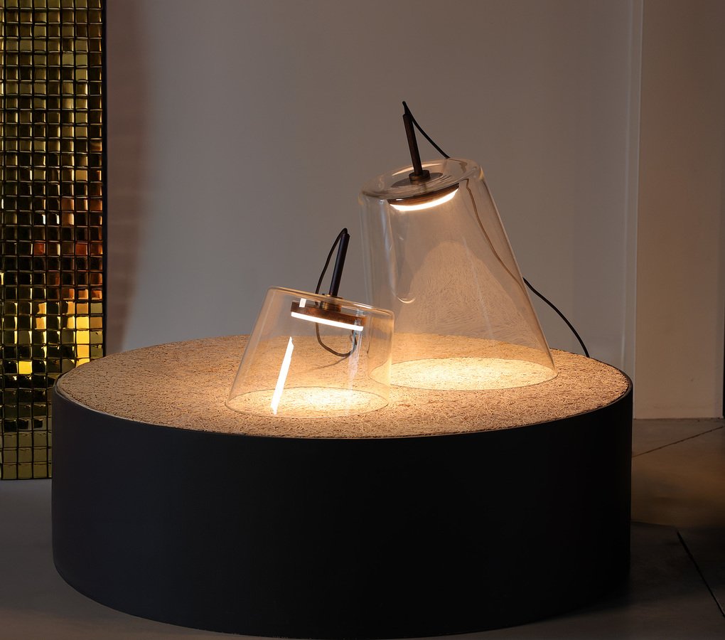 Fez blown-glass lamp glowing on a dark pedestal.