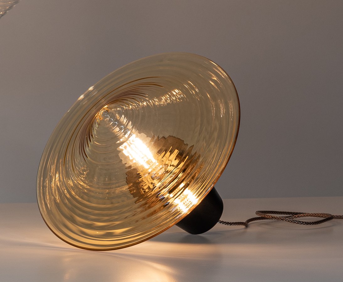 Disca-T glass table lamp in warm light.