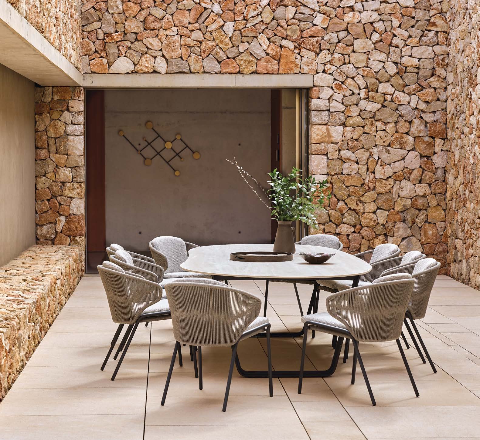 Air table with woven chairs in a stone courtyard.